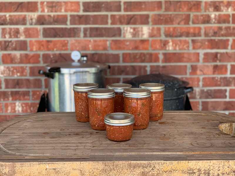 Canned Salsas in front of pressure canner and water bath canner